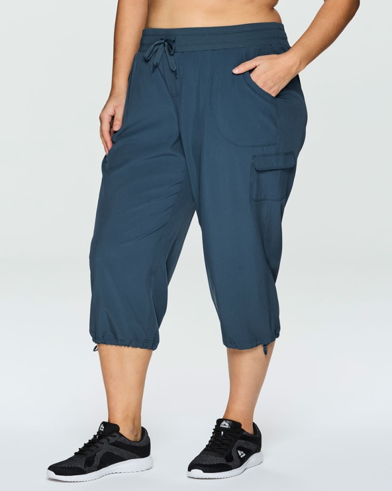 Front of a model wearing a size 1X Plus Prime Anywhere Cargo Capri in Teal by RBX Active. | dia_product_style_image_id:348471